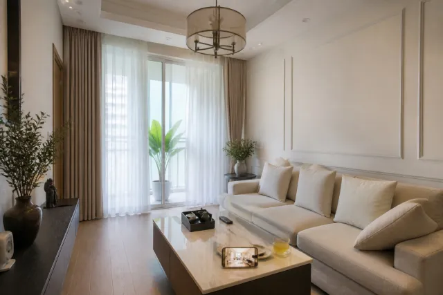 Phòng khách tân cổ điển nhẹ với tường kem, phào chỉ trắng, sofa kem và điện thoại hiển thị phối cảnh AI